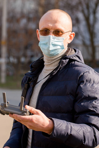 Сервеєр у захисній масці контролює квадрокоптер. Концепція захисту коронавірусу - Фото, зображення