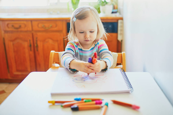 Adorable little girl painting with color pencils at home, in kindergaten or preschool. Creative games for kids staying at home - Photo, image