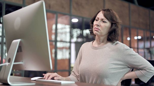 Біль у спині, незручна стара жінка, що працює на комп'ютері
 - Фото, зображення