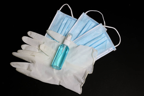 Gumikesztyű, alkoholos spray palack és orvosi maszk a vírusvédelem alapvető elemei. - Fotó, kép