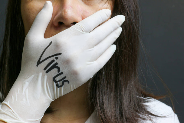 Egy nő becsukja a száját, hogy megvédjen egy vírust. - Fotó, kép