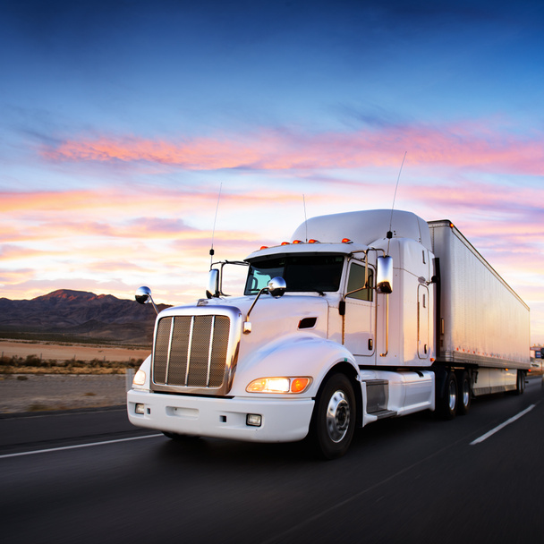 vrachtwagen en snelweg bij zonsondergang - vervoer achtergrond - Foto, afbeelding