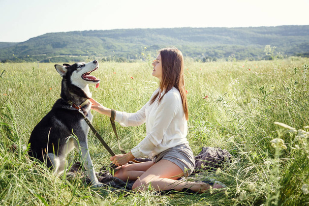Gyönyörű fiatal nő játszik vicces husky kutya kint a parkban. Nyár és naplemente. Feltétel nélküli szeretet. Szibériai husky kedvenc háziállata. Állattenyésztés. Törzskönyvezett kutya koncepció. Legjobb barátok.. - Fotó, kép