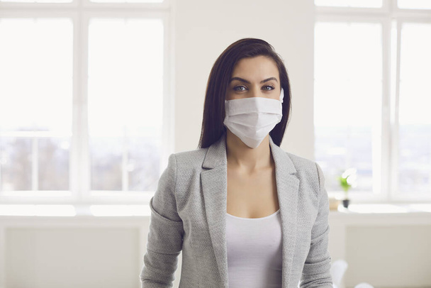 Danger of infection of the virus coronavirus infection. Businesswoman in medical mask at office - Foto, immagini