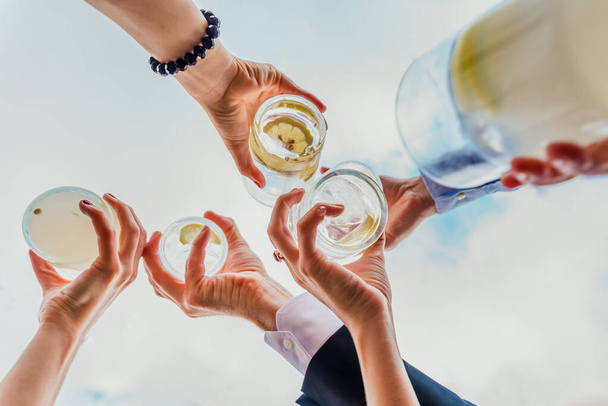 Emberek csoportja, akik az italaikat kínáló italokkal ünneplik a sikert. - Fotó, kép