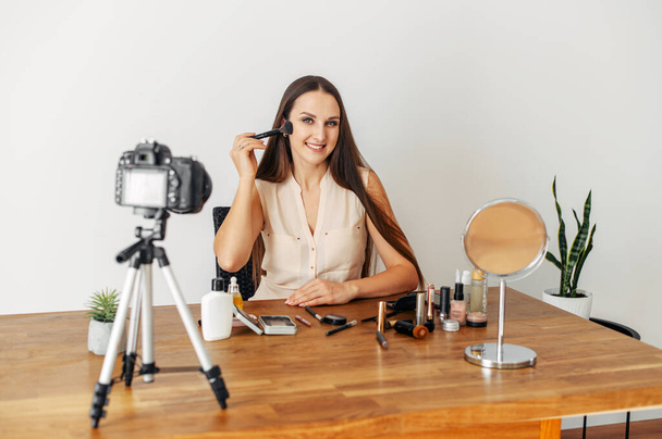 Young attractive woman records makeup tutorial - Fotó, kép