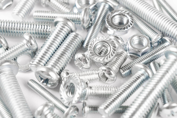 Metal bolts and nuts  in a row background. Chromed screw bolts and nuts isolated. Steel bolts and nuts pattern. Set of Nuts and bolts. Tools for work. - Zdjęcie, obraz