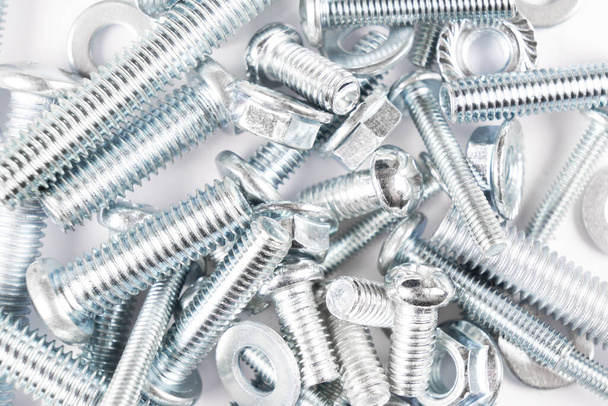 Metal bolts and nuts  in a row background. Chromed screw bolts and nuts isolated. Steel bolts and nuts pattern. Set of Nuts and bolts. Tools for work. - 写真・画像