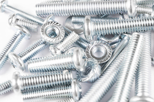 Metal bolts and nuts  in a row background. Chromed screw bolts and nuts isolated. Steel bolts and nuts pattern. Set of Nuts and bolts. Tools for work. - 写真・画像