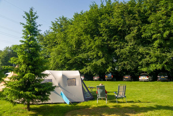 A beautiful shot of a camping tent on a grassy field near trees - Foto, afbeelding