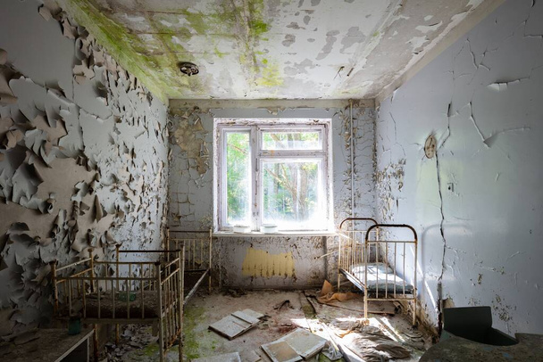 Hospital beds within an abandoned hospital in Pripyat, Chernobyl - Fotoğraf, Görsel