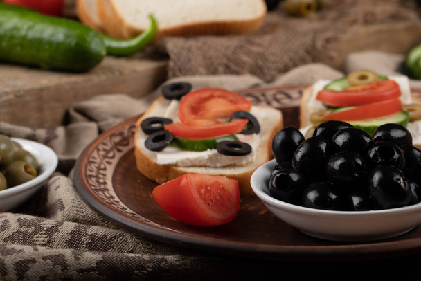 Sandwiches con tomate y aceitunas negras
. - Foto, Imagen