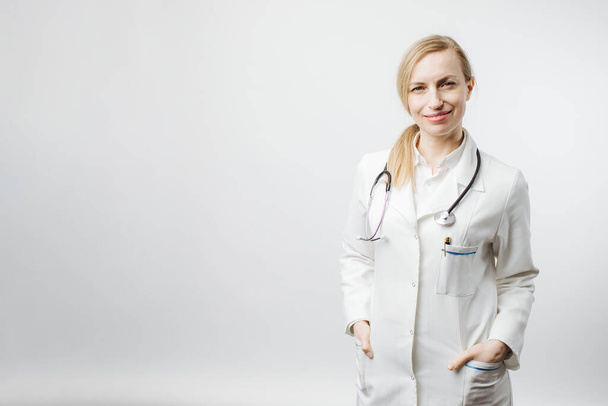 Веселая женщина-врач в медицинской форме позирует перед камерой
. - Фото, изображение