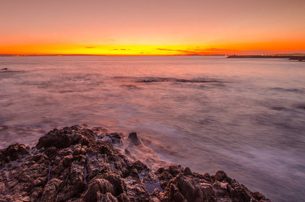 Waves breaking over rocks at sunset in Langebaan lagoon. Western Cape, South Africa - Фото, зображення