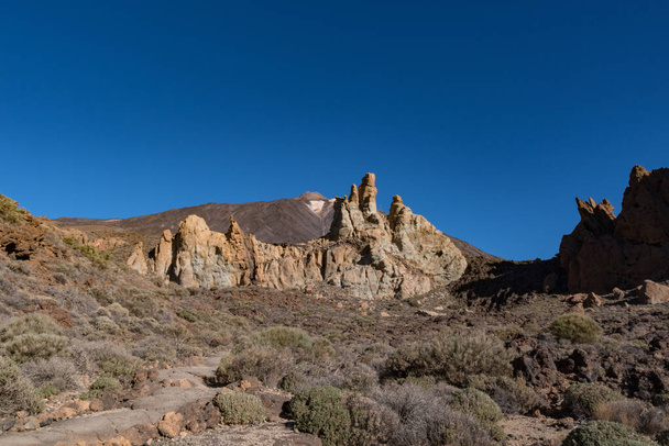 Vista de la formación rocosa única de Roques de Garcia con la famosa cumbre del volcán de montaña Pico del Teide en el fondo al amanecer, Parque Nacional del Teide, Tenerife, Islas Canarias, España
 - Foto, imagen