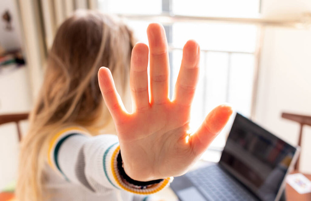 Ein Mädchen zeigt fünf Finger in die Kamera, Nahaufnahme, Frauenpower, Frauen arbeiten, Mädchen arbeiten im Laptop, harte Arbeit, Mädchen arbeiten, blonde Haare - Foto, Bild