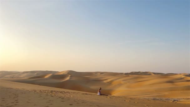 Birleşik Arap Emirlikleri 'ndeki Rub al-Khali çölündeki kum tepeleri arasında bir kız. - Video, Çekim