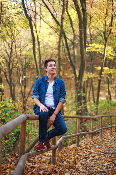 młody zamyślony i marzycielski facet w leśnym parku cieszy się relaksem i świeżością natury - Zdjęcie, obraz