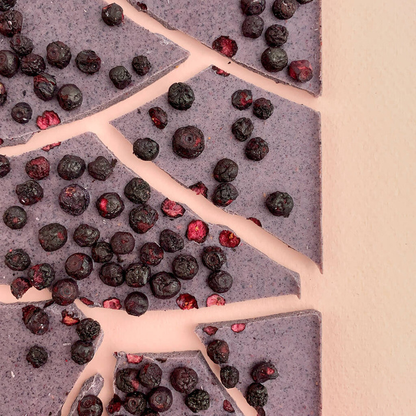 Owocowa czekolada na jasnoróżowym tle z jagodami - Zdjęcie, obraz