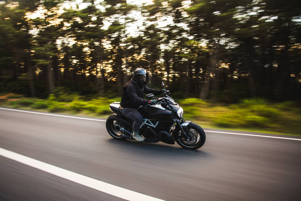 Guidare una moto nella strada forestale
 - Foto, immagini