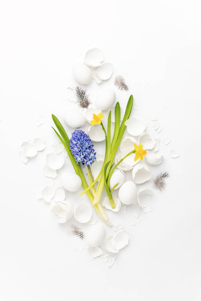 Velikonoční přání nebo leták pozadí, jarní slavnostní složení květin vejce a vaječné skořápky ležící ploché - Fotografie, Obrázek