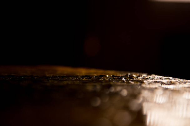 Rain drops on a round wooden table at night - Zdjęcie, obraz