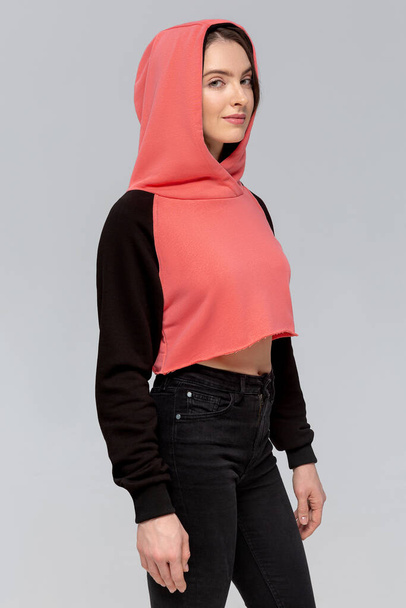Donna in mini felpa con cappuccio nera e rosa, modello per logo o design di marca
 - Foto, immagini