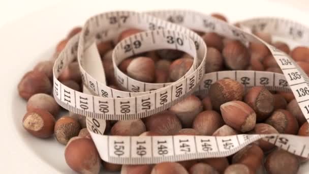 eating nuts makes weight gain, high-calorie foods, nuts and obesity,nuts and tape measure over 360 degree rotating stand, - Footage, Video