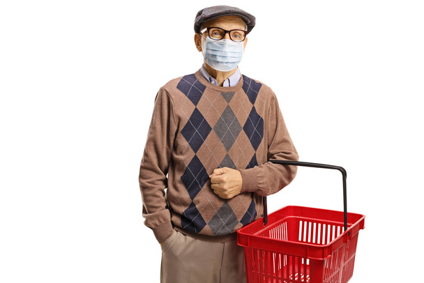 Elderly man wearing a medical face mask and holding a shopping basket isolated on white background - Foto, afbeelding