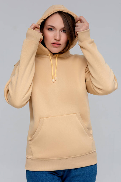 Woman in gold hoodie, mockup for logo or branding design - Foto, afbeelding