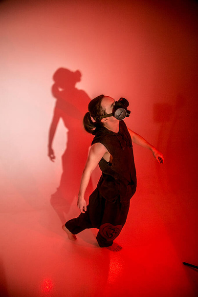 A man in a gas mask on red background dancing - Fotografie, Obrázek