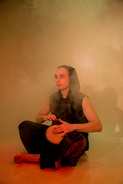 A young man playing bongo in smoke - Foto, Imagem
