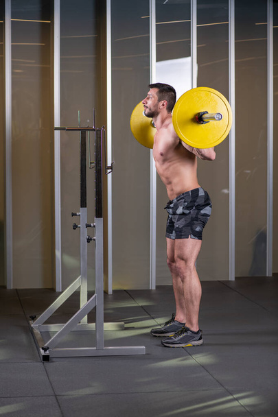Sexy muscular man doing squat exercise. Side view - Valokuva, kuva