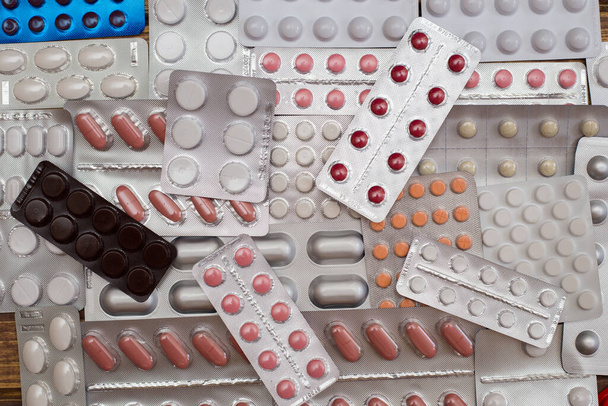 Куча разноцветных таблеток лежит на
 - Фото, изображение