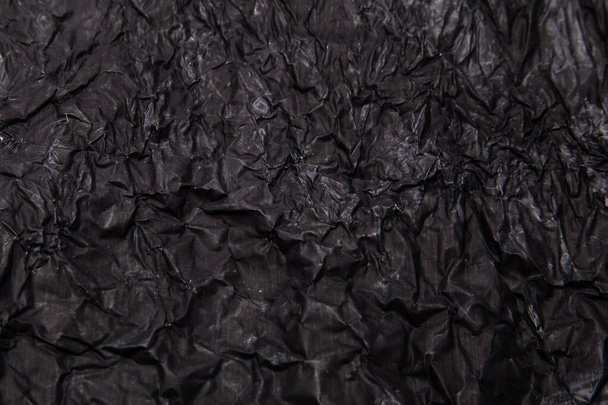 Black background. A crumpled texture. Close-up - Photo, Image
