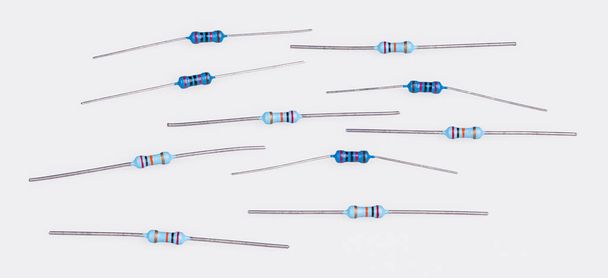 Set of blue miniature carbon resistors on a white background. Group of passive two terminal electrical components with colorful bands of electronic standard color code. Use for printed circuit boards. - Foto, imagen