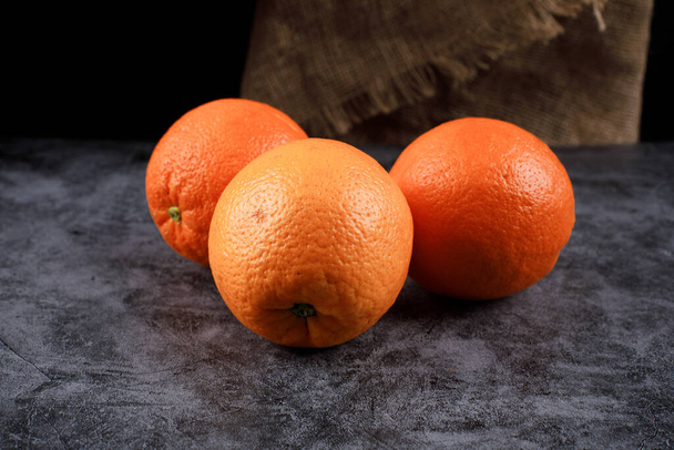 Trojúhelník zarámovaný třemi pomeranči na modrém stole. - Fotografie, Obrázek