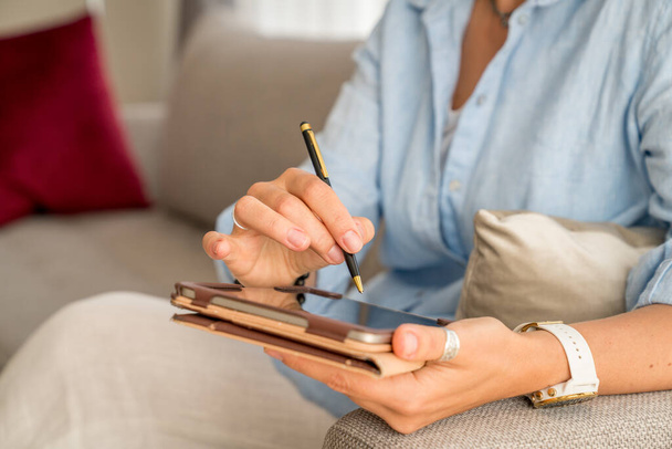 Close-up of woman's hands holding tablet PC and a stylus pen - Fotó, kép