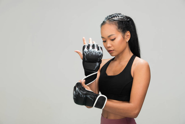 Asian Tan Skin Fitness woman exercise punch air wear Boxing Gloves Black sport bra mulberry purple pants, studio lighting gray background copy space, concept Woman Can Do Sport 6 packs - Photo, Image