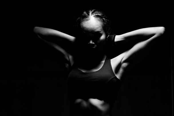 Asijské opálení kůže Fitness žena cvičení strečové paže box hmotnost punč v tmavé pozadí, studio osvětlení gradient šedá horní světlo stín nízká expozice kopírovat prostor, koncept žena může dělat sport 6 balení - Fotografie, Obrázek