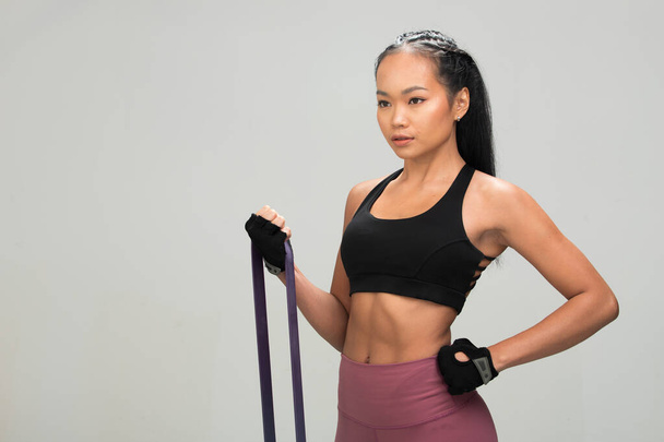 Ázsiai Tan Skin Fitness nő gyakorlat bemelegítés stretch ellenállás szalagok abs viselni Fekete sport melltartó eperfa lila nadrág, stúdió világítás szürke háttér fénymásolás hely, koncepció Woman Can Do Sport 6 csomag - Fotó, kép