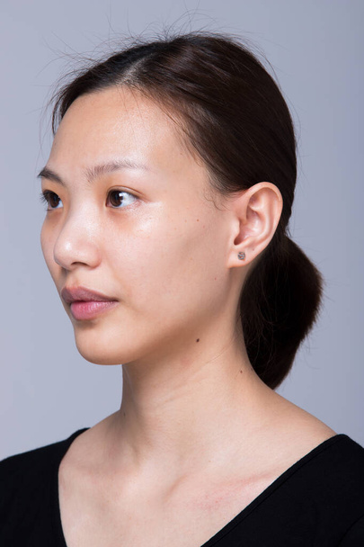 Mujer asiática antes de aplicar maquillaje estilo de pelo. sin retoque, cara fresca con acné, labios, ojos, mejilla, piel suave agradable. Estudio de iluminación de fondo gris, para tratamiento de terapia estética
 - Foto, Imagen