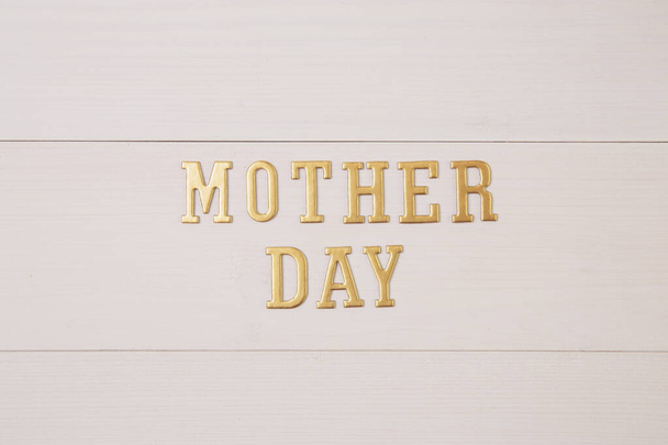 Happy mother day with gold text on wooden table, feeling romantic and care with decoration, word and alphabet mother day in festive with sign on desk, congratulation, top view, holiday concept. - Foto, afbeelding