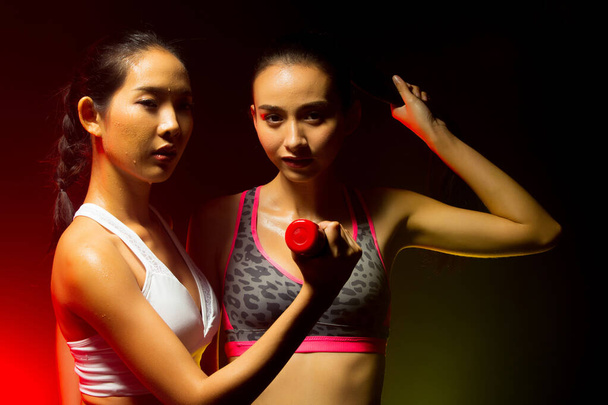 2つのアジアタンスキンフィットネス女性運動ボクシング体重パンチでフォグ煙暗い背景環境,スタジオ照明黄色バックライトコピースペース,コンセプト2女性はスポーツを行うことができます6パック - 写真・画像