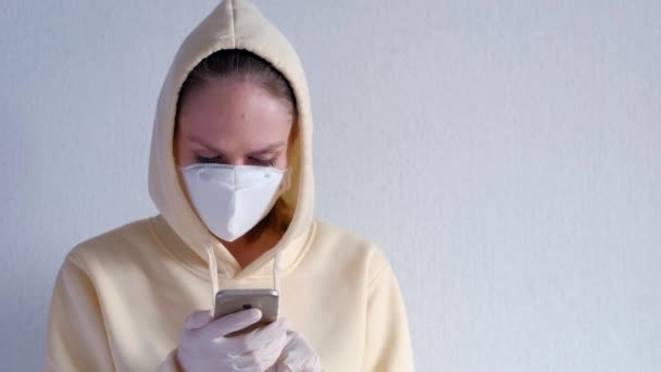 Woman wearing a protective mask using mobile phone isolate on a white background. Protect themselves from corona virus infection in. - Materiaali, video