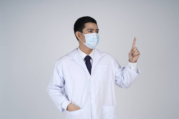 Asian doctor man in flu mask against with a corona virus pandemic, or prevent flu disease or cold during winter - Valokuva, kuva