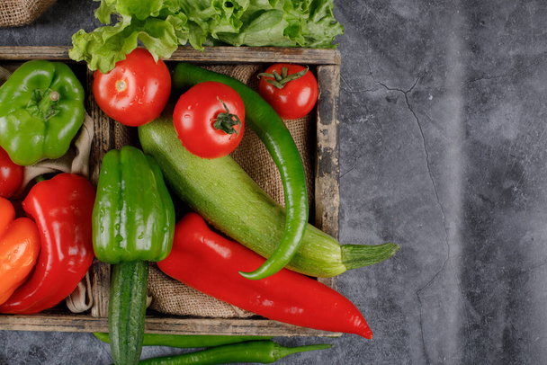 Ein Holztablett mit rotem und grünem Gemüse. - Foto, Bild