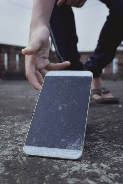 Σπασμένη οθόνη συσκευής ενός κινητού τηλεφώνου. Σπασμένη οθόνη αφής του ψηφιακού tablet. Κατεστραμμένη παλιά χρησιμοποιημένη τεχνολογία. - Φωτογραφία, εικόνα
