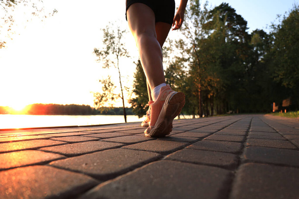 Pies de corredor corriendo por carretera primer plano en zapato, al aire libre al atardecer o al amanecer
 - Foto, imagen
