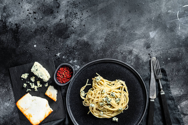 Spagetti paszta krém kék sajt szósszal és dióval. Olasz házi étel. Fogantatás egy ízletes, vegetáriánus ételre. Fekete háttér. Első látásra. Fénymásolási hely. - Fotó, kép